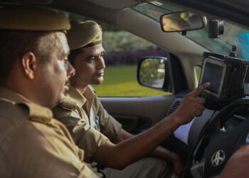 Police officers conducting an operation with cryptocurrency-related documents and seized devices.