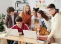 Students in a classroom setting engage with laptops during an AI training session.