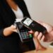 A person uses a smartphone to make a crypto payment at a retail store.