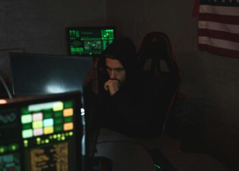 A hacker using a computer surrounded by cryptocurrency icons and digital security symbols.