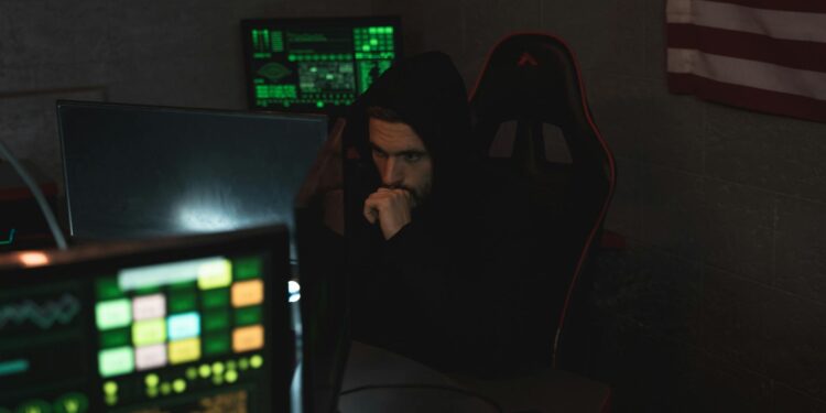 A hacker using a computer surrounded by cryptocurrency icons and digital security symbols.