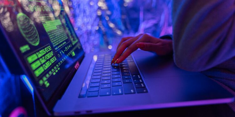 A hacker typing on a laptop with cryptocurrency logos in the background, highlighting DeFi vulnerabilities.