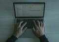 A cybersecurity expert analyzes code on a laptop, revealing vulnerabilities in software.