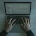 A cybersecurity expert analyzes code on a laptop, revealing vulnerabilities in software.