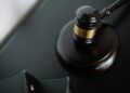A gavel rests on legal documents, symbolizing justice in cryptocurrency fraud cases.