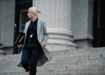 A woman standing in front of a courthouse, linked to a Bitcoin fraud case.