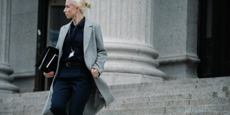 A woman standing in front of a courthouse, linked to a Bitcoin fraud case.