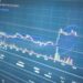A stock market display showing Nakamoto's logo and trading statistics amidst financial graphs.