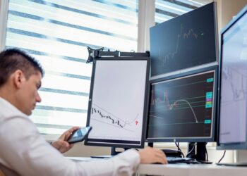 Traders analyzing stock market charts with election prediction market data on screens.