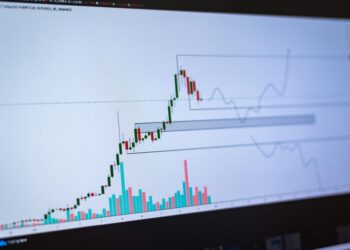 Stock market charts in decline with cryptocurrency logos in the background, reflecting financial turmoil.