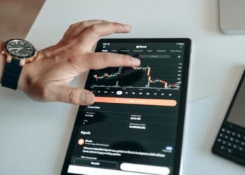 Investors examining cryptocurrency charts and Bitcoin gains on digital screens.