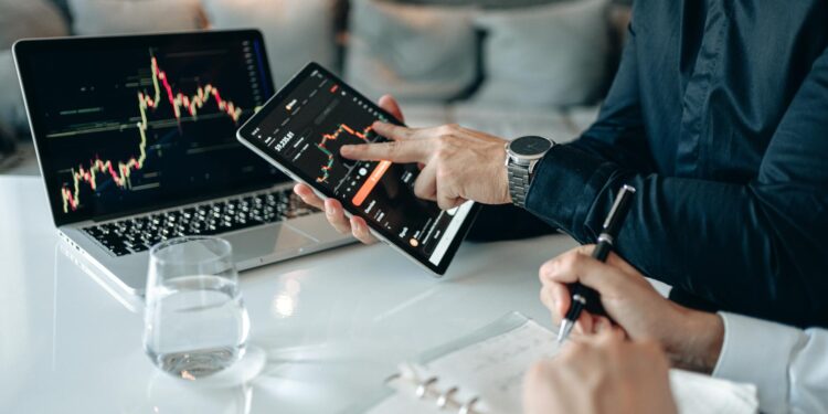 A person analyzing cryptocurrency data on a laptop with digital charts and graphs displayed.