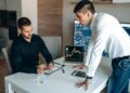 A group of professionals analyzing cryptocurrency data on screens in a corporate setting.