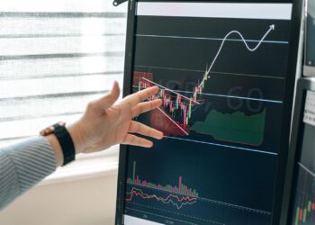 A financial analyst studies Bitcoin ETF charts and graphs on a digital screen.