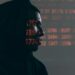 A hacker in a dark hoodie surrounded by digital code, highlighting cloud security breaches.