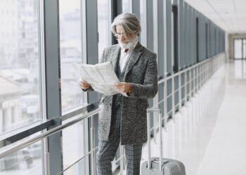 A man in a suit carrying a briefcase walks through an airport terminal.