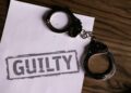 Delio CEO in handcuffs, leaving court after crypto fraud proceedings.