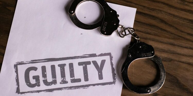 Delio CEO in handcuffs, leaving court after crypto fraud proceedings.