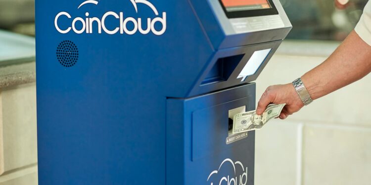 Bitcoin and crypto ATMs displayed in a public location with financial notices nearby.
