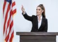Melania Trump speaking at a podium during a White House event, expressing denial of Epstein ties.