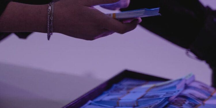 A person examining digital currency tokens with a warning sign about counterfeit risks.