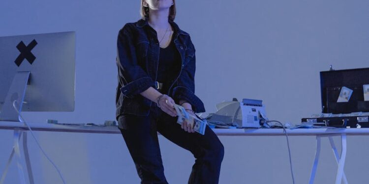 A hacker at a computer, with cryptocurrency charts and dollar signs in the background.