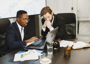 Two executives discussing blockchain technology at a conference, showcasing digital finance innovation.