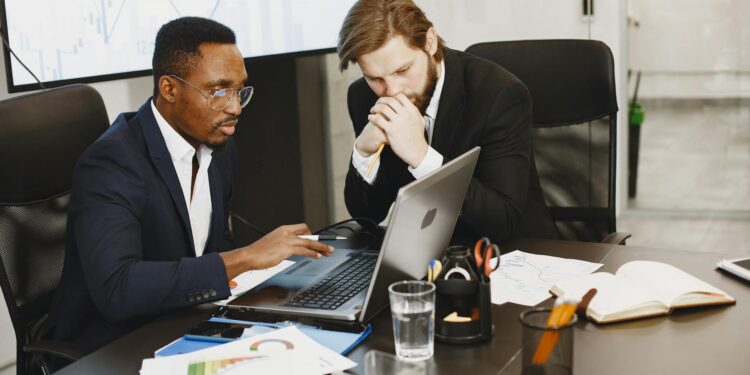 Two executives discussing blockchain technology at a conference, showcasing digital finance innovation.