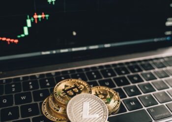 Visual showing a hacker in a digital environment with cryptocurrency symbols and financial graphs.