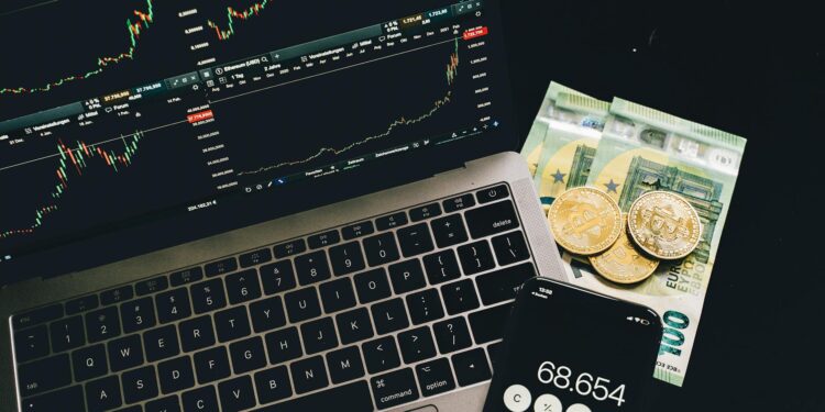 Wealthy investor reviewing cryptocurrency assets on a laptop with financial charts displayed.