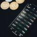 A warning sign with a phishing hook and a smartphone displaying cryptocurrency apps.