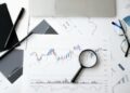 A gavel rests on financial documents with charts, symbolizing regulatory challenges in prediction markets.