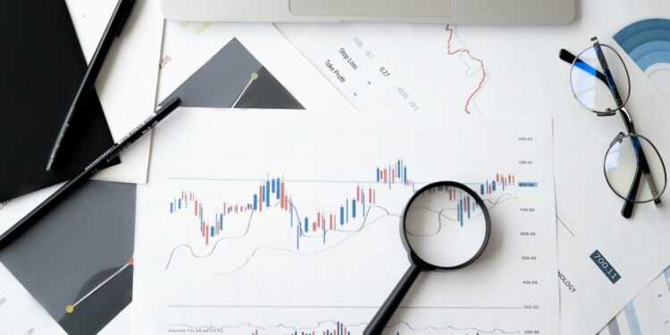 A gavel rests on financial documents with charts, symbolizing regulatory challenges in prediction markets.