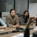 Executives from major tech firms discuss AI standards at a conference table.