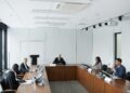 KBank executives discussing blockchain remittances with Ripple representatives in a conference room.