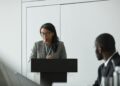 OpenAI CEO speaking at a podium about AI superintelligence regulations and risks.