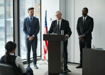 David Woodcock at a podium addressing SEC enforcement strategies in finance regulation.