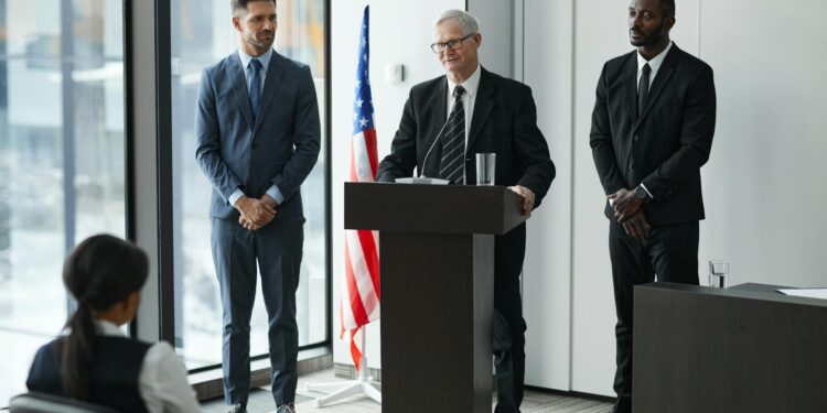 David Woodcock at a podium addressing SEC enforcement strategies in finance regulation.