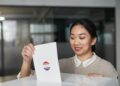 A woman in business attire exits a government building, carrying documents related to voter data.