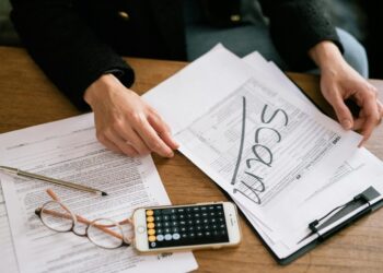 An investor examines financial documents, symbolizing the threat of impersonation scams.