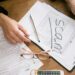 Financial advisor reviewing crypto tax forms with a calculator and laptop.