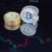 Bitcoin coins stacked with a background graph showing rising investment trends.