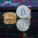 A bank office with financial charts and cryptocurrency coins on a desk, symbolizing consolidation.