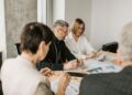 Small crypto firm employees discussing compliance documents and financial regulations.