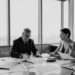 Business meeting with finance professionals discussing a takeover deal.