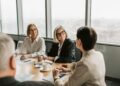 Central banks meeting around a table discussing stablecoin regulations and cooperation.
