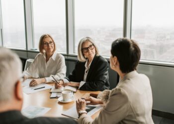 Central banks meeting around a table discussing stablecoin regulations and cooperation.