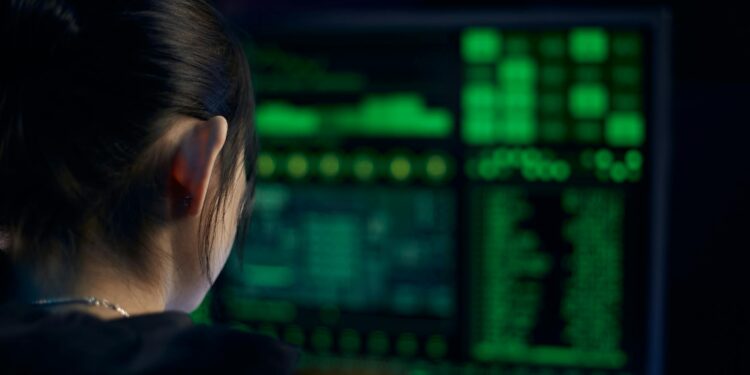 Police officers examining computer screens filled with cryptocurrency data and codes.