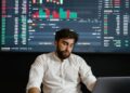 A trader monitoring cryptocurrency prices on a digital screen with Bitcoin and Ethereum charts.