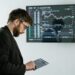 A trader analyzes charts on a digital device, symbolizing crypto trading advancements.